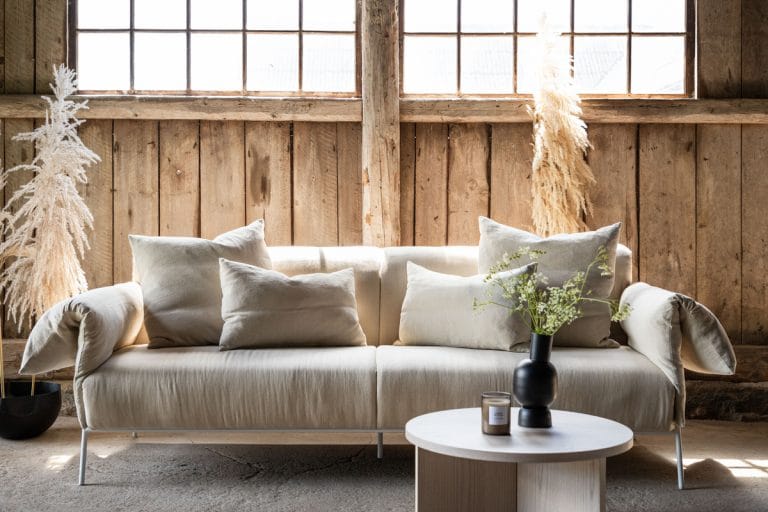 Ockero Beige sofa – šviesiai smėlinės spalvos pagalvėlės, baltas plieninis rėmas, skandinaviško dizaino trivietė sofa