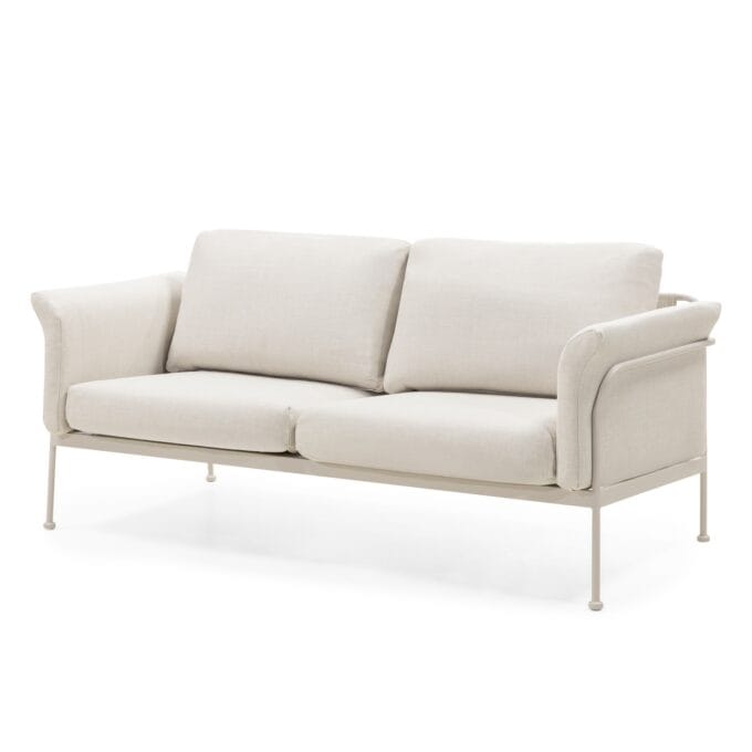 „Marinelli Beige“ lauko baldų komplektas su sofa, foteliais ir apvaliu stalu, pastatytas šviesioje terasoje.