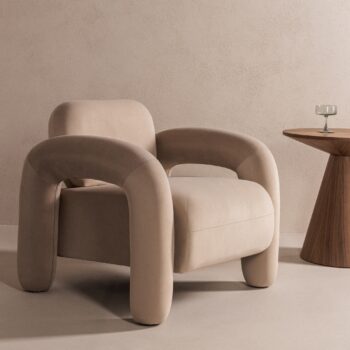 Vico fotelis šviesiai smėlio spalvos aksomo, su masyviais porankiais ir apvaliomis linijomis